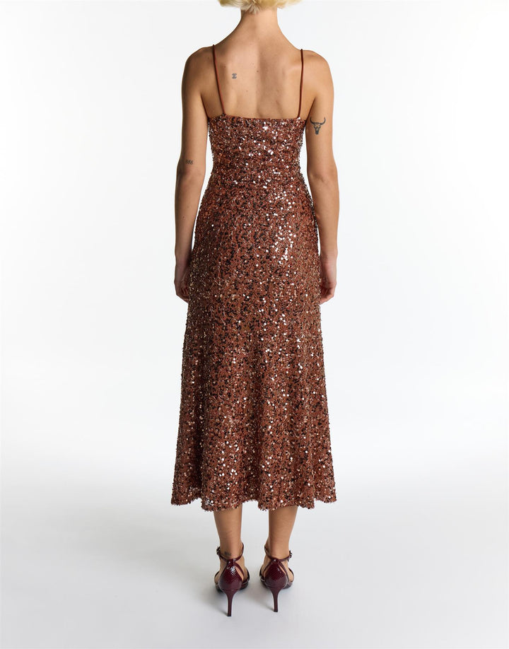 Person wearing a brown sequin dress on a white background